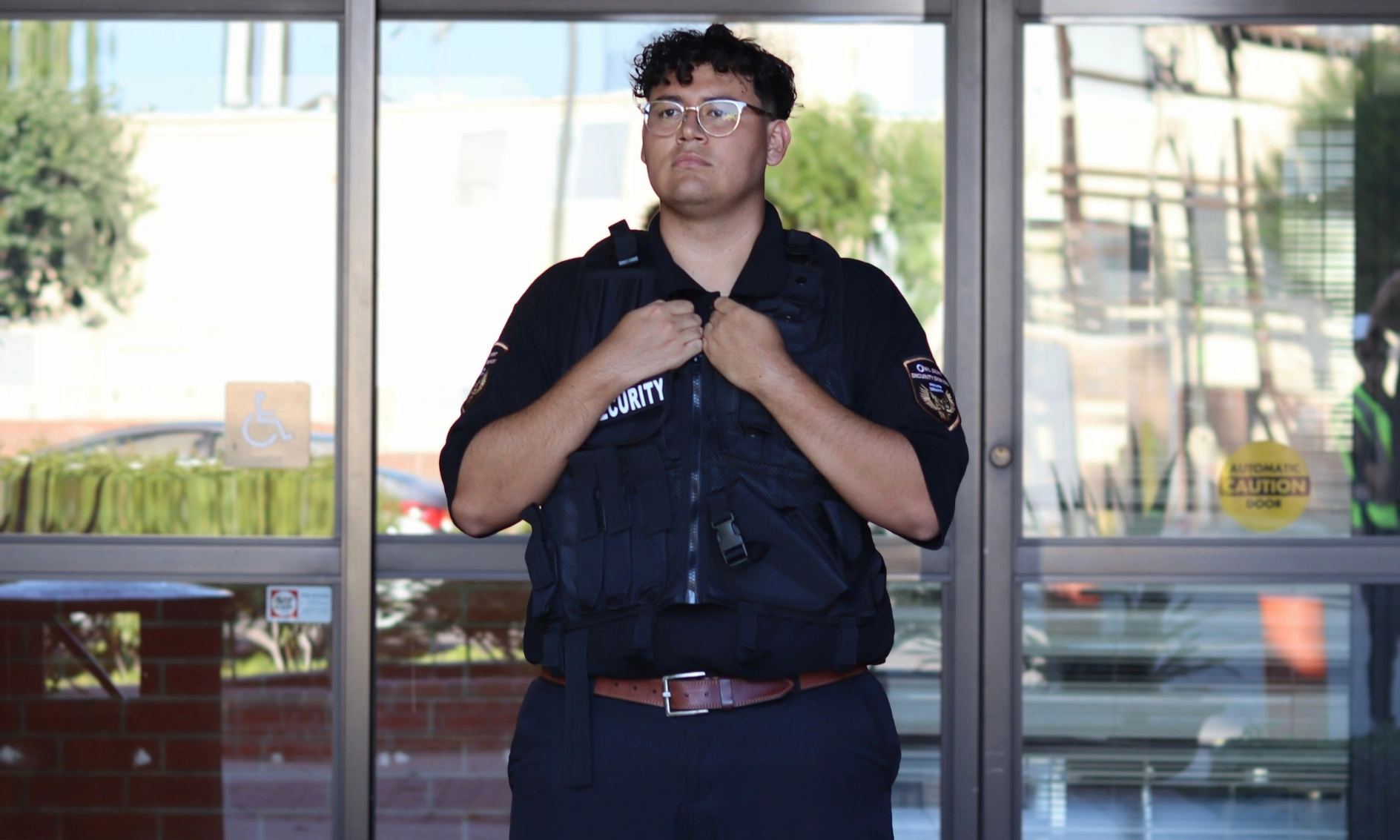 apartment security guard in Los Angeles wearing security vest and standing outside of entrance